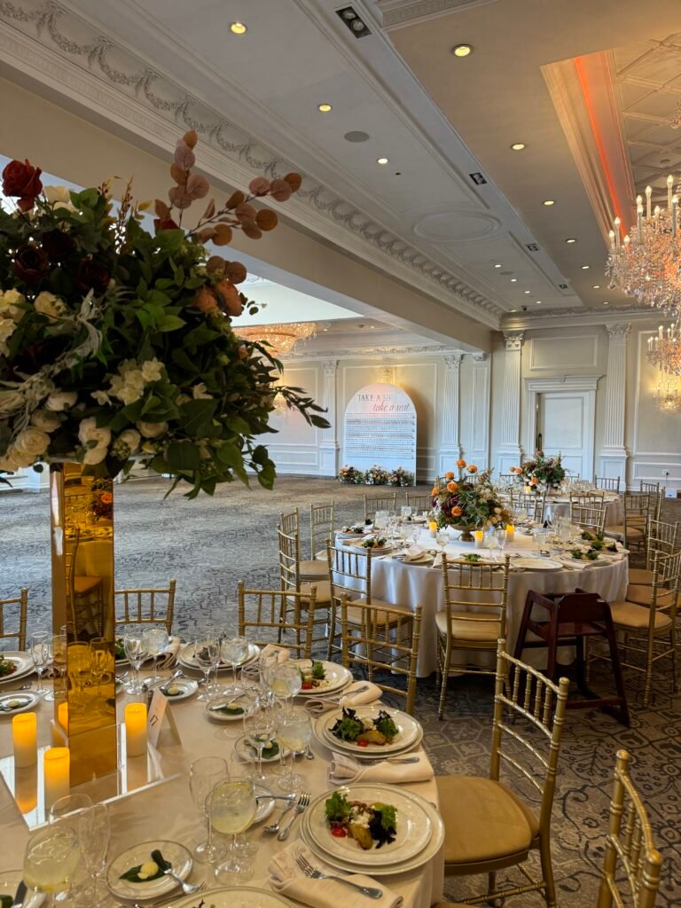 Wedding reception hall with floral centerpieces and gold chairs